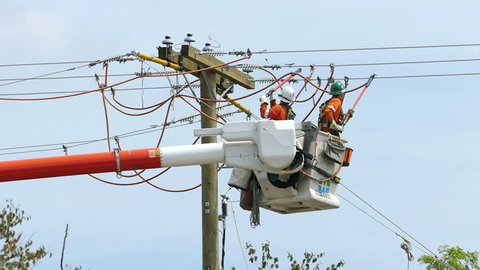 VANCOUVER, BC, CANADA, JULY 2015: A pair of hydro repair linemen work together to resolve various issues on a telephone pole in suburbia in the city of Vancouver.