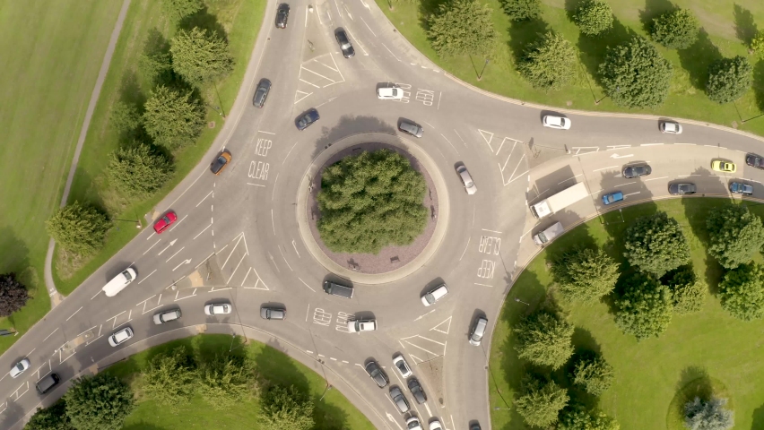 4K aerial footage of a busy roundabout at peak time rush hour with cars and vehicles queuing in atraffic jam