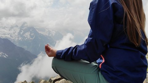 Close-up of yoga woman meditating outdoors with hands in Mudra in rocky mountains