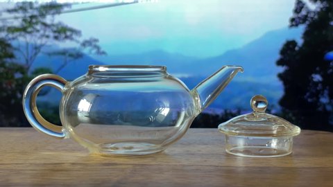 Brewing green tea in a glass teapot. Timelapse