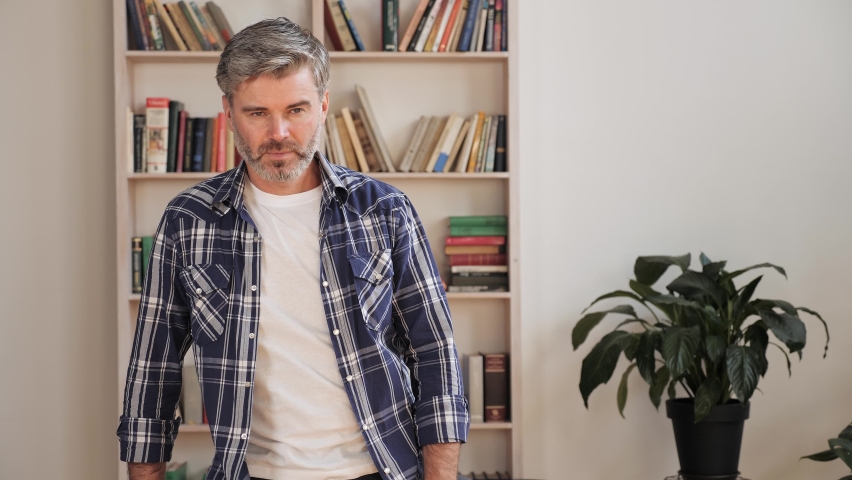 Portrait of middle age business man freelancer standing at home feeling pain back ache tired expression time to take rest. Grey hair man suffering from ache in shoulders through sedentary work. Royalty-Free Stock Footage #1080274928
