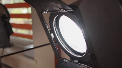 Halogen source of constant lighting equipment. Lightweight fresnel spotlight searchlight is on set during shooting of film. Movie cinema production. Stage, scene. Lamphead for interior. Gafer's work