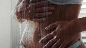 Unrecognizable Young Female Washing Flat Belly Rubbing And Massaging Body With Hands Standing Under Falling Water In Bathroom Indoors. Skincare And Bodycare Concept. Cropped Shot, Slow Motion