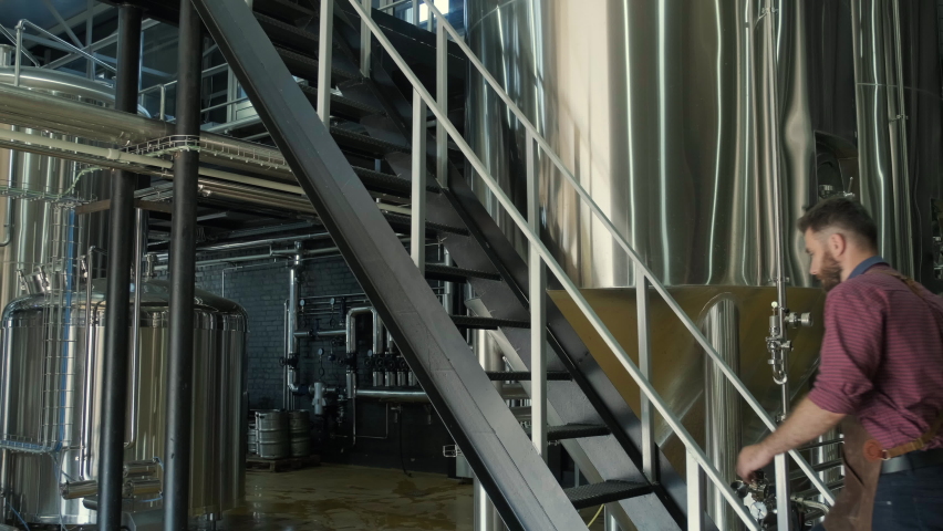 Young male brewer works at a modern brewery