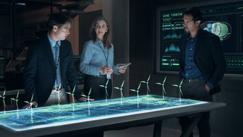 Professional Engineers and Specialists Working on Renewable Clean Energy Innovative Project Analyzing the Efficiency of Wind Turbines using Futuristic Holographic AR Technology. Cinematic 4K.