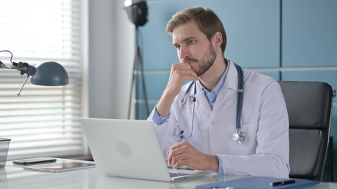 Doctor Thinking while Working on Laptop in Clinic