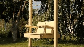 Beautiful wooden swing in the garden. White swing. Video