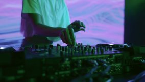 DJ plays music at night club party for crowd of joyful people. Trendy girl in spot light of multi-color neon. Funky dj mixing dance rhythm on mixer board. Energy of indie dancer at festival show scene - Powered by Shutterstock - Get 15% off with code: PIKWIZARD15