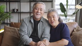 Asian elderly couple chatting through the camera for a video call with distant family - Powered by Shutterstock - Get 15% off with code: PIKWIZARD15