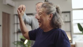 Slow motion Asian mature senior couple is dancing and smiling at home. - Powered by Shutterstock - Get 15% off with code: PIKWIZARD15