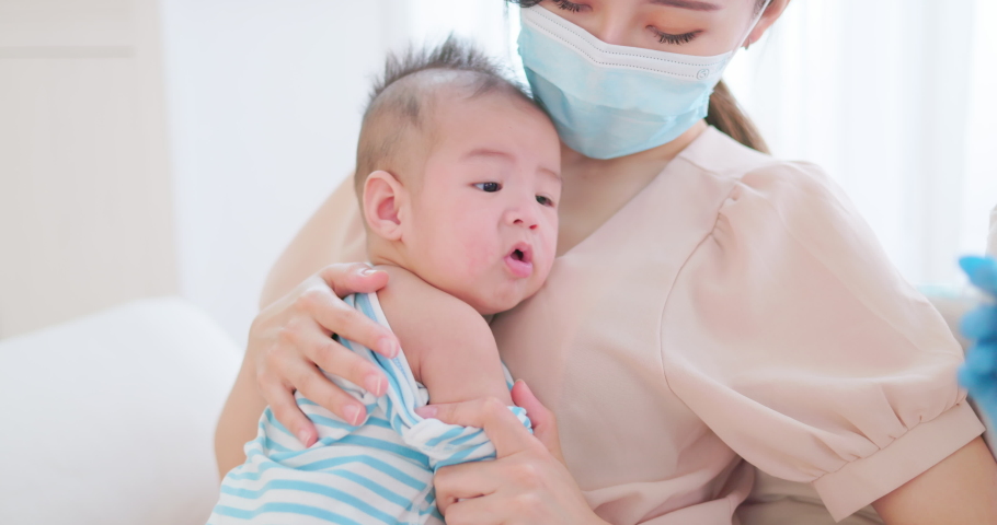 authentic shot of asian mother wearing face mask holds her baby for vaccinated by doctor Royalty-Free Stock Footage #1080303488
