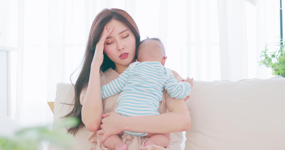 authentic shot of asian mother holding her crying baby on sofa has postpartum depression Royalty-Free Stock Footage #1080303524