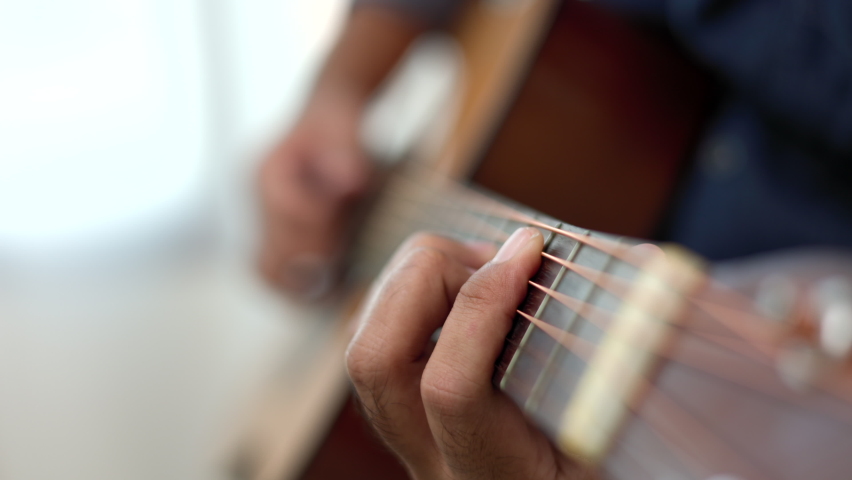 Lifestyle concept. Young asian musician playing guitar in living room at home on this weekend. Relaxing with song and music. Asian man having fun playing acoustic guitar | Shutterstock HD Video #1080306500