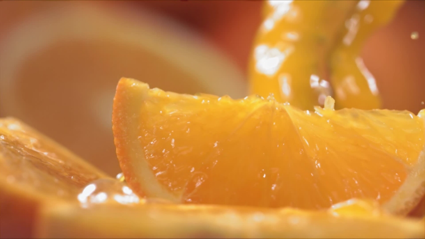 Slow Motion Shot of Orange Juice Splashing through Orange Slices at 1400fps. Royalty-Free Stock Footage #1080311111