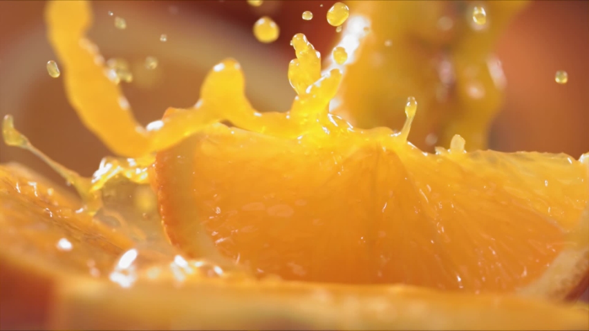 Slow Motion Shot of Orange Juice Splashing through Orange Slices at 1400fps. | Shutterstock HD Video #1080311111