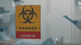Close up of danger sign against coronavirus outbreak in hospital ward. Infectious zone in isolation and quarantine against covid 19 pandemic with biohazard symbol on glass. Lockdown virus area - Powered by Shutterstock - Get 15% off with code: PIKWIZARD15