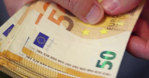 Counting euro cash money in hands. Slow motion and close up of 50 euro banknotes, good earnings