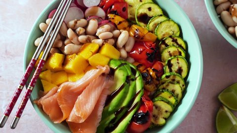 poke bowl with smoked fish, avocado, mango and beans. healthy food