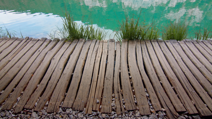 Attractive girl in a hat walking along a wooden path along the lake. Plitvice Lakes, Croatia