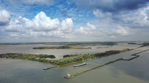 River Ijssel flowing in the Ketlemeer in the IJsseldelta in Overijssel and Flevoland, The Netherlands with a freight ship sailing onto the lake.
