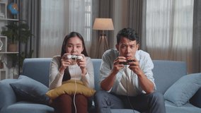 Young Asian Couple Is Playing Video Games At Home
