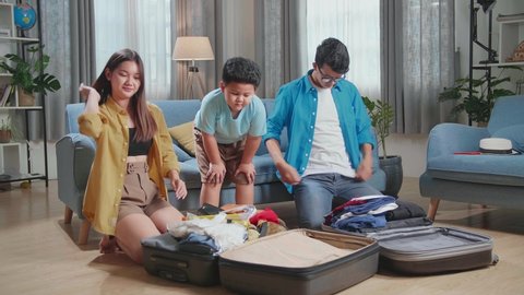 Happy Asian Family Helping Close Suitcase For A New Journey, Son Celebrating And Dancing, Luggage For Travel Holidays And Vacation
