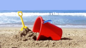 While playing in the water, a Childs toy plastic bucket and shovel are left in the sand during a summer holiday.