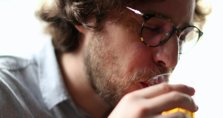Casual happy smiling man drinking beer. Person taking a drink sipping alcholic beverage