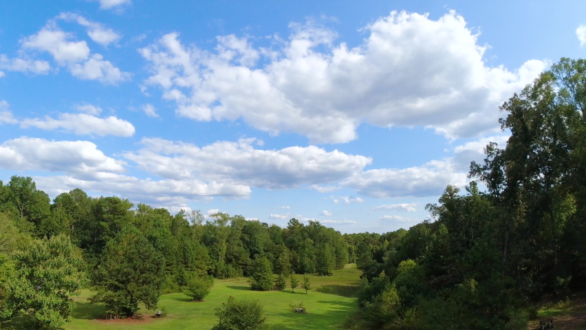 Late summer cloud movements over a parklike landscape soon to change into Autumn, time lapse.
