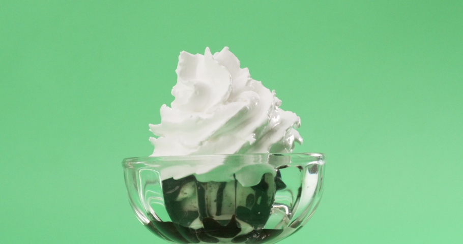 Melted chocolate sauce flowing whipped cream on green background. Royalty-Free Stock Footage #1080331772