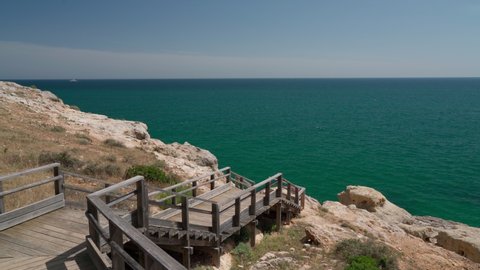 Wonderful view of the Portuguese coast of Carvoeiro in summer, walking along the wooden paths. Overlooking the blue sea. Shooting in motion with a stabilizer.