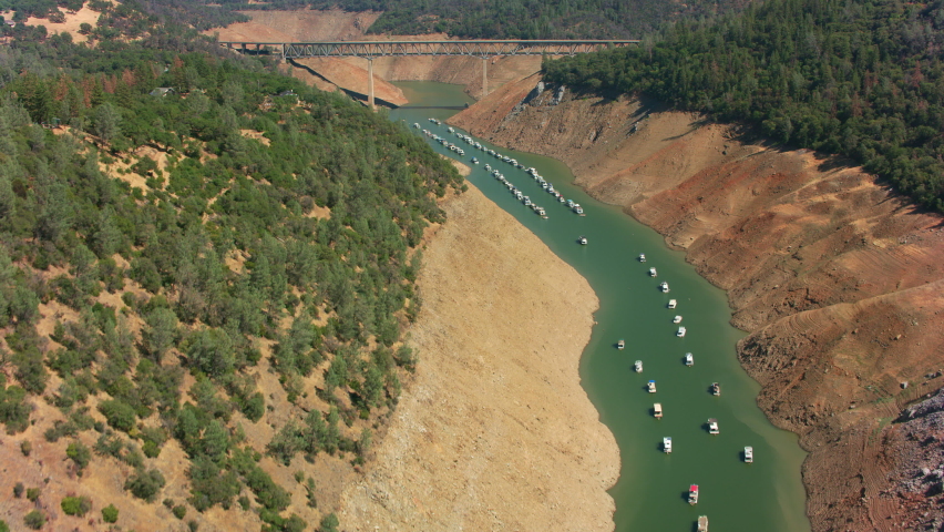 Lake Oroville, California circa-August, 2021: Aerial view of boats lined up in Lake Oroville due to low water. Shot with Cineflex from Helicopter with RED 8K. Royalty-Free Stock Footage #1080335423