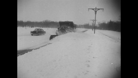 CIRCA 1956 - Snow plows and shovels are used to clear roads and cars after a drastic blizzard.