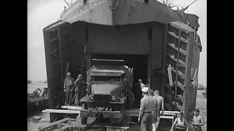 CIRCA 1945 - Trucks are unloaded from a US Navy LST onto a pontoon dock in the Philippines.