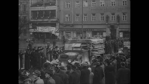 CIRCA 1939 - Nazi soldiers drive through Czech city streets, lined with cheering crowds.