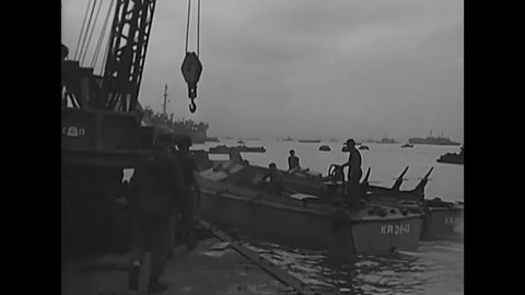 CIRCA 1945 - Cranes are used to unload crates from a US Army LCVP onto a truck on a pontoon pier in the Philippines.