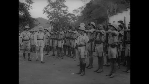 CIRCA 1940s - Black and white troops stationed in French occupied Africa present arms to French army officers.