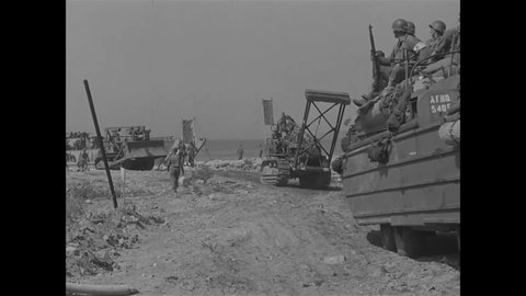 CIRCA 1944 - American soldiers advance on the shores of occupied France in Dukws, bulldozers and other vehicles.