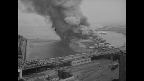 CIRCA 1938 - Smoke and flames rise from a pier in Vancouver, Canada.