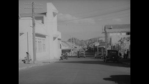 CIRCA 1940s - The fighting French drive trucks and cars through a village.