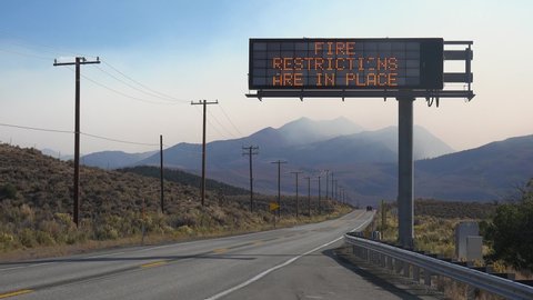 LAKE TAHOE, CALIFORNIA - CIRCA 2020s - An electronic sign along a highway warns that fire restrictions are in place, as the Caldor Fire rages.