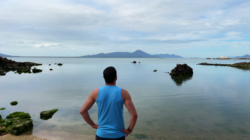man with open arms looking at the sea