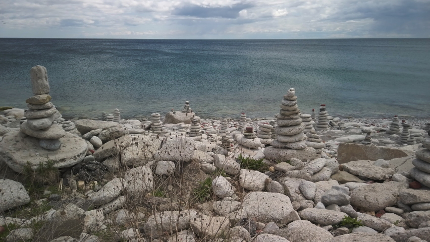 Wide shot of rock cairns on the Lake Ontario shoreline