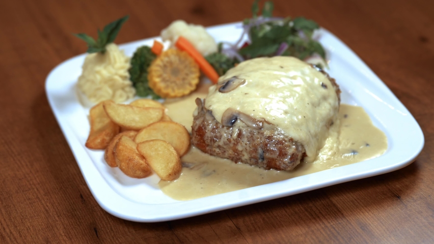 Cordon bleu with cheese meal on a wooden table with rice and potatoes - top  view 4k