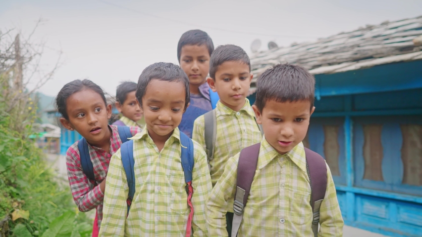 Shot of a group of happy and adorable primary school children wearing uniforms with backpacks walking through a rural village lane. school re opening, learning, and education concept. Royalty-Free Stock Footage #1080363545