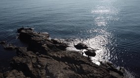 Nice aerial drone view of Black sea coast. Fisherman silhouette on the rocks.
