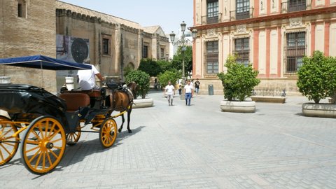 August 15, 2021, Seville, Andalusia, Spain - The traditional calash taking tourists for a ride, with coach and horseman in the city centre, close to the beautiful cathedral.