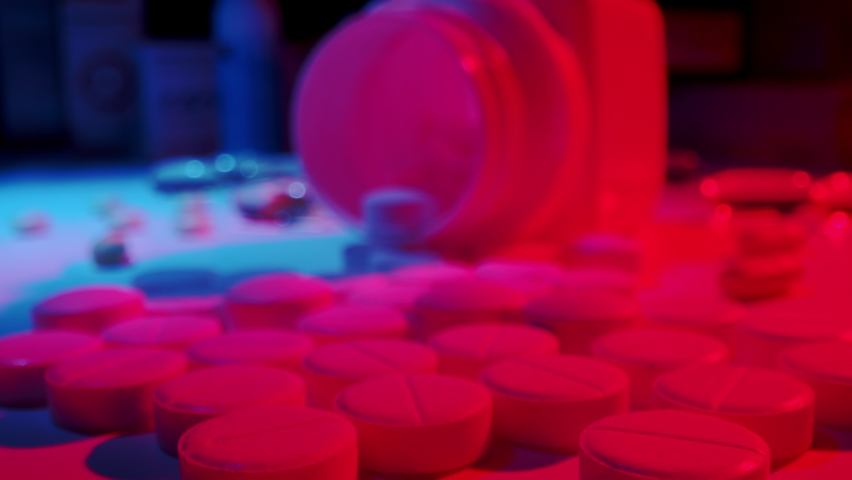 Macro shot of medications pills and tablets spilled out of pill container. Multicolored drugs Probe lens shot. Royalty-Free Stock Footage #1080370547