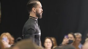 Beautiful male model walking down the runway podium. Men on fashionable expo week. Haute couture catwalk, elegant people vogue. Beauty guy catwalks on fashion show stage, delicate person defile look. - Powered by Shutterstock - Get 15% off with code: PIKWIZARD15