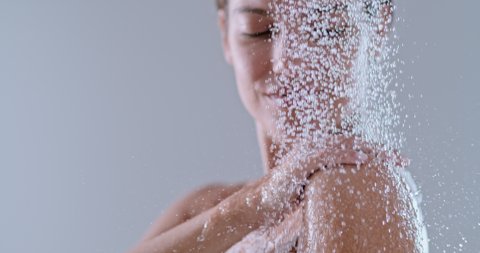 slow motion of a woman taking a shower. beautiful girl enjoying the water drops on body